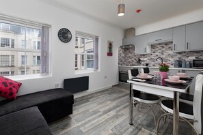 A modern apartment with a dining area, kitchen, and living space. - 1 Bed Flat - Sleeps 2 - Wifi (Scarborough)