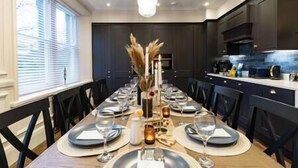 A long dining table set for a meal with plates, glasses, and a centerpiece.