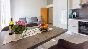 A modern kitchen with a built-in oven and a dining area with a table set for two. - 500 metres to the beach with barbecue, air conditioning (Dramalj)