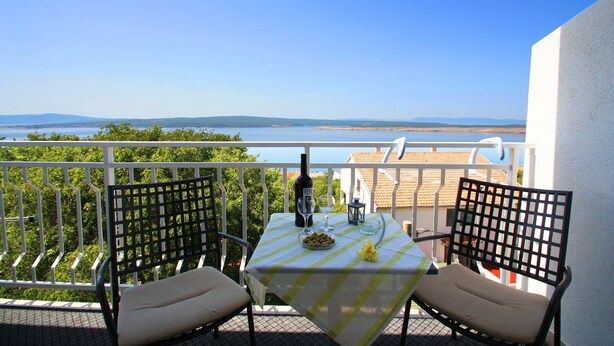 A balcony with a table set for two, overlooking a scenic view of the sea and distant hills. - 500 metres to the beach with barbecue, air conditioning (Dramalj)