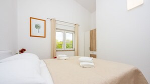 A hotel room with a bed, a window with curtains, a framed picture on the wall, and a mirror. - Great sea view only 500 metres to the beach (Dramalj)