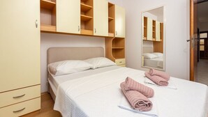 Un dormitorio con cama, dos mesitas de noche, armario y espejo.