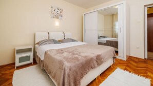 A bedroom with a bed, bedside table, and a mirror. - Only 100 metres to the crystal-clear Adriatic Sea (Jadranovo)