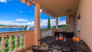 A balcony with a table, chairs, and a pitcher of orange juice. - Only 100 metres to the crystal-clear Adriatic Sea (Jadranovo)