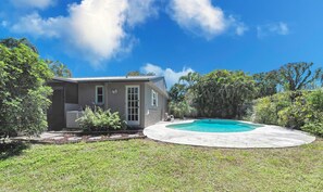 Situated on a well-manicured lawn, this two-story house offers a swimming pool surrounded by a deck.