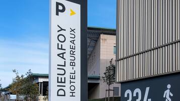 Señal del Hotel Dieulafoy-Bureau con un símbolo de estacionamiento, indicando un área de estacionamiento cerca.