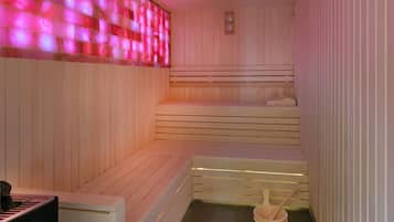 A sauna with wooden benches and a wooden bucket with a wooden spoon.