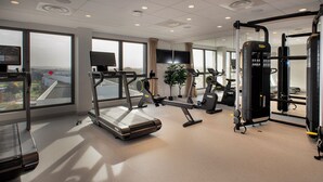 A modern gym with treadmills, stationary bikes, and weight machines. - Sevenline Aparthotel Purpan Toulouse (Toulouse)