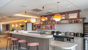 A modern kitchen with a bar area, bar stools, and a variety of kitchen appliances. - Sevenline Aparthotel Purpan Toulouse (Toulouse)