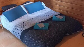Una cama con ropa de cama estampada, almohadas y una manta.