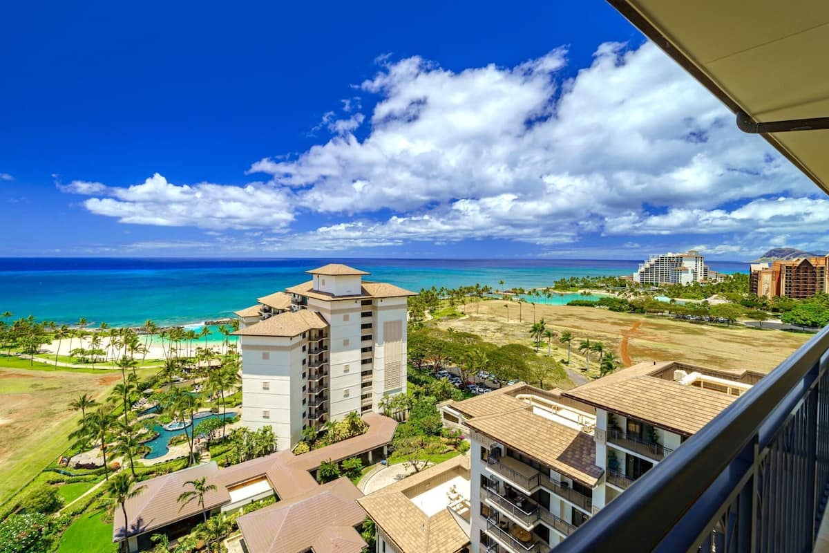 A hotel with multiple buildings, a pool area, and a view of the ocean and beach.