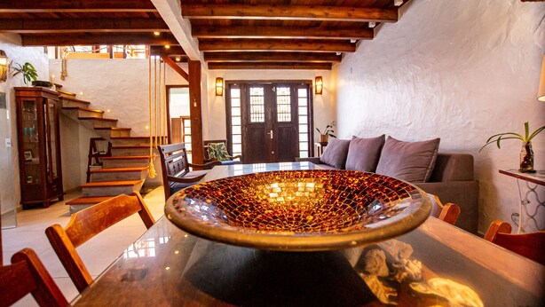 A dining area with a large, ornate glass bowl centerpiece on a wooden table, surrounded by chairs.