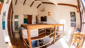 A spacious room with a wooden bed, a TV, and a view of the outdoors.