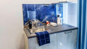 A modern kitchen with a sink, a coffee maker, and a small countertop. - THE OSIRIS (Marsaxlokk)