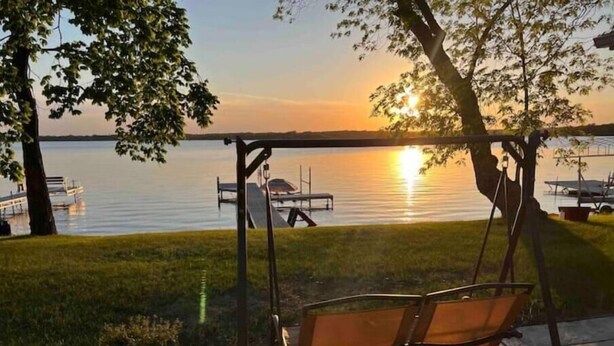 A swing chair overlooking a lake at sunset. - R and M Escape (Detroit Lakes)