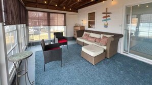 A cozy room with a wooden ceiling, a sofa set, a small table, and a chair. - R and M Escape (Detroit Lakes)