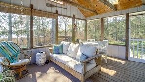 Una terraza de madera con un sofá, sillas y una mesa.