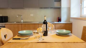 A dining table with a bottle of wine, wine glasses, and bowls.