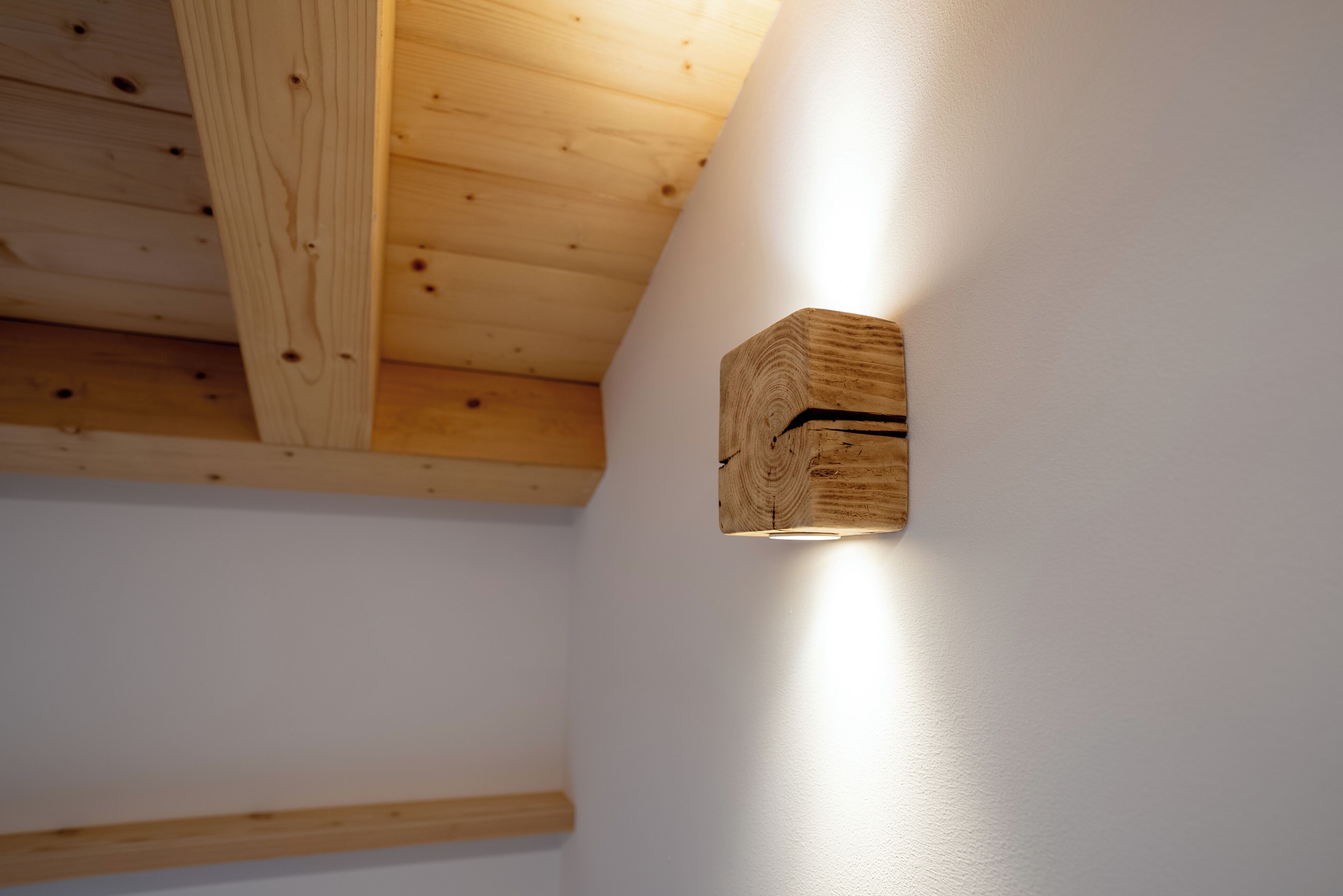 Techo de vigas de madera con una lámpara empotrada.