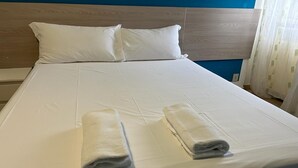 A neatly made bed with white linens and two folded towels on the bed. - VENICE NIGHT6 DOUBLE ROOM SHARED TOILETA (Mestre)