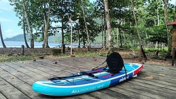 A blue kayak with a black seat on a wooden deck.