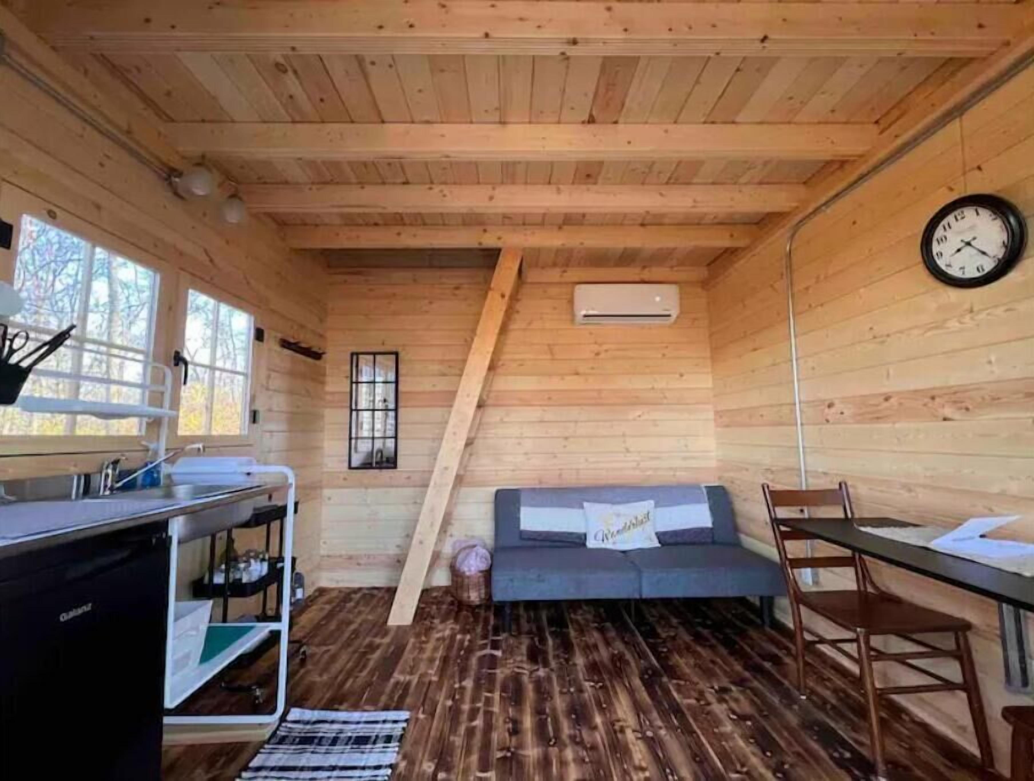 A cozy cabin interior with a kitchenette, a sofa, and a dining area.