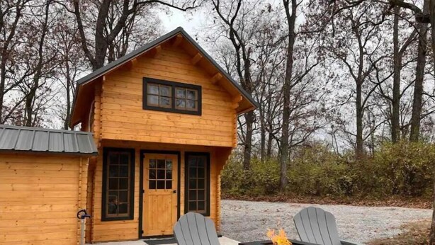A wooden cabin with a front door, two windows, and a small porch area. - Après Vine Tiny Cabin at Panther's Rest Farm (Makanda)