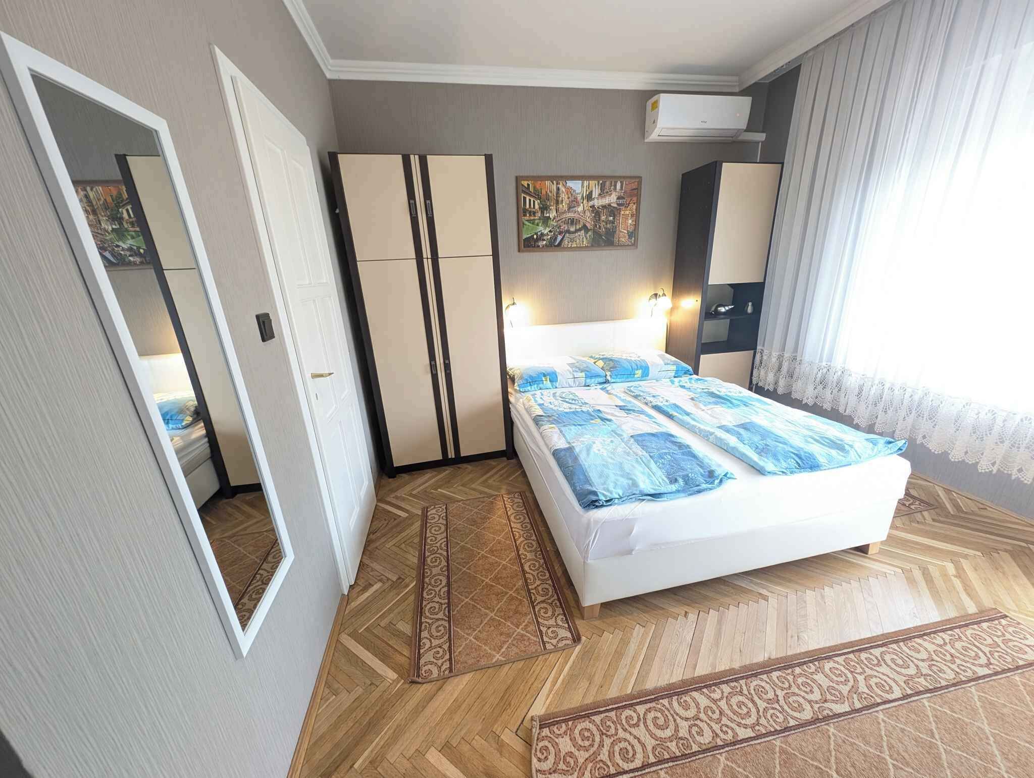 Ein Schlafzimmer mit Bett, Kleiderschrank und einem Bild an der Wand.