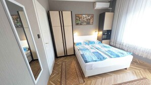 Un dormitorio con cama, armario y un cuadro en la pared.