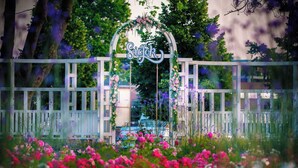 Una verja blanca de madera con un arco floral y el nombre 'Sioborn' en cursiva.
