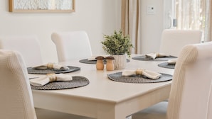 A dining table set with placemats, a potted plant, and two wooden salt and pepper shakers. - Serenity, a tranquil 4-bed, 3-bath home minutes away from UC Merced.  (Merced)