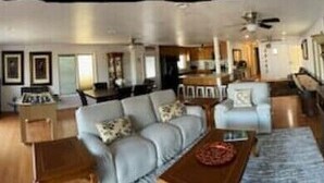 A spacious living area with a sofa set, dining table, and kitchen area. - Big fun lake at beaver lake (Rogers)