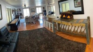 A spacious living area with a black leather sofa, a coffee table, and a decorative bench. - Big fun lake at beaver lake (Rogers)