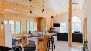 A spacious cabin interior with a kitchen, dining area, and living room.