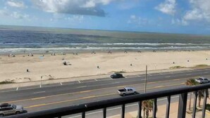 Een strand met een weg op de voorgrond en een heldere lucht.