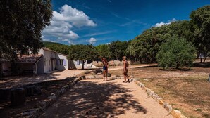 A pathway leading to a building with a tiled roof, surrounded by trees and a clear sky. - Douceur d'Olive - Maison avec piscine privée (Fox-Amphoux)