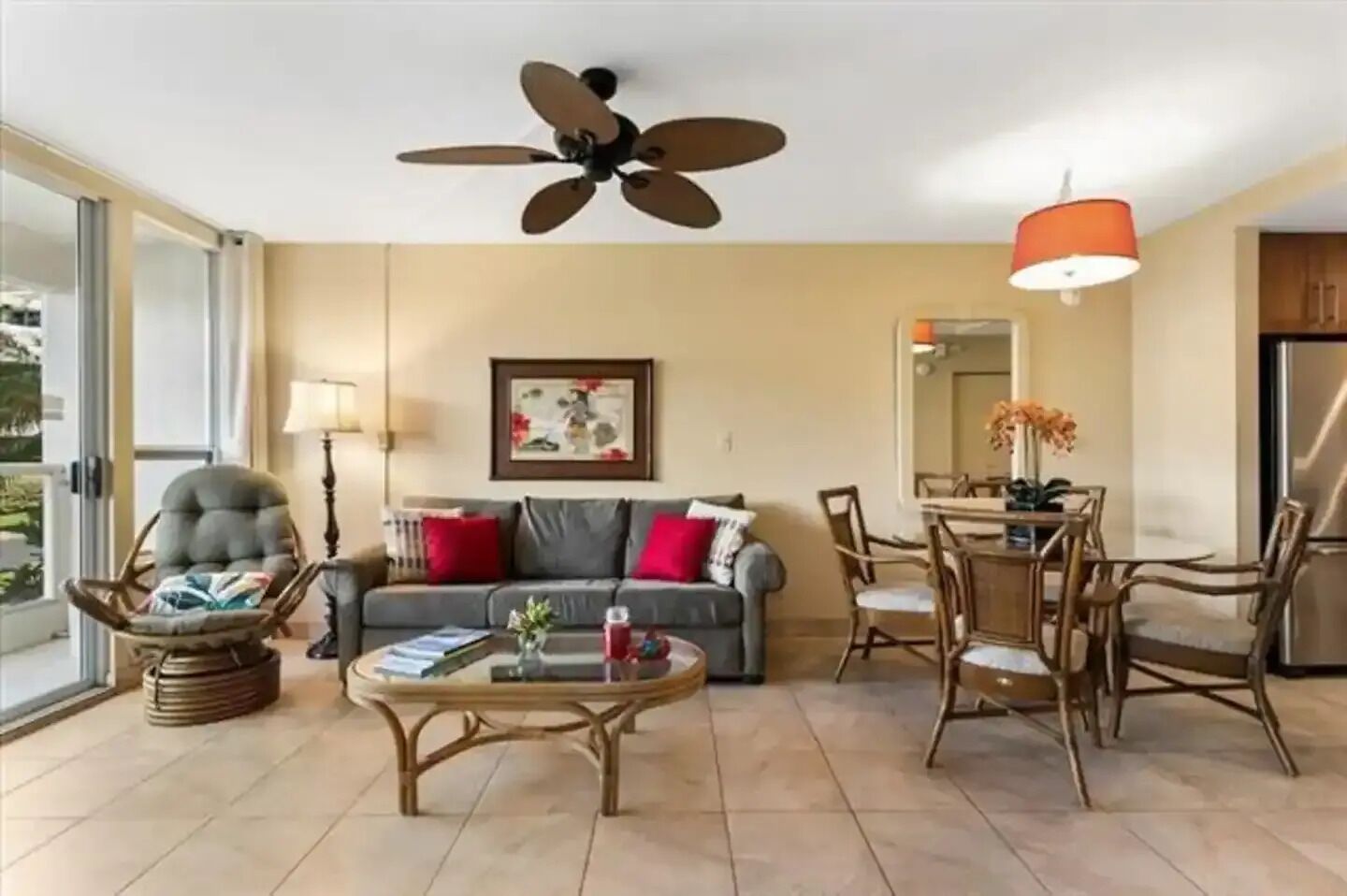 Una sala de estar con un sofá, sillones, una mesa de centro y un comedor con sillas y una mesa.