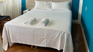 A neatly made bed with white linens and towels, a wooden headboard, and a blue wall. - VENICE NIGHT DOUBLE ROOM SHARED TOILETC6 (Mestre)