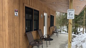 Un edificio in legno con due cartelli che avvertono della presenza di alci. Quattro sedie sono posizionate all'esterno.