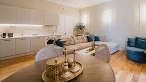 Ein modernes Wohnzimmer mit Essbereich, ausgestattet mit einer Sofagarnitur, einem Couchtisch und einem Esstisch mit Dekorationselementen.