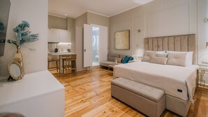 Une chambre moderne avec un grand lit, un petit canapé, un bureau et un coin repas.