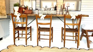 A dining area with a wooden table and chairs, a mirror above the table, and a rustic wall. - Sandusky's Original Luxury Bachelorette Mansion  (Sandusky)