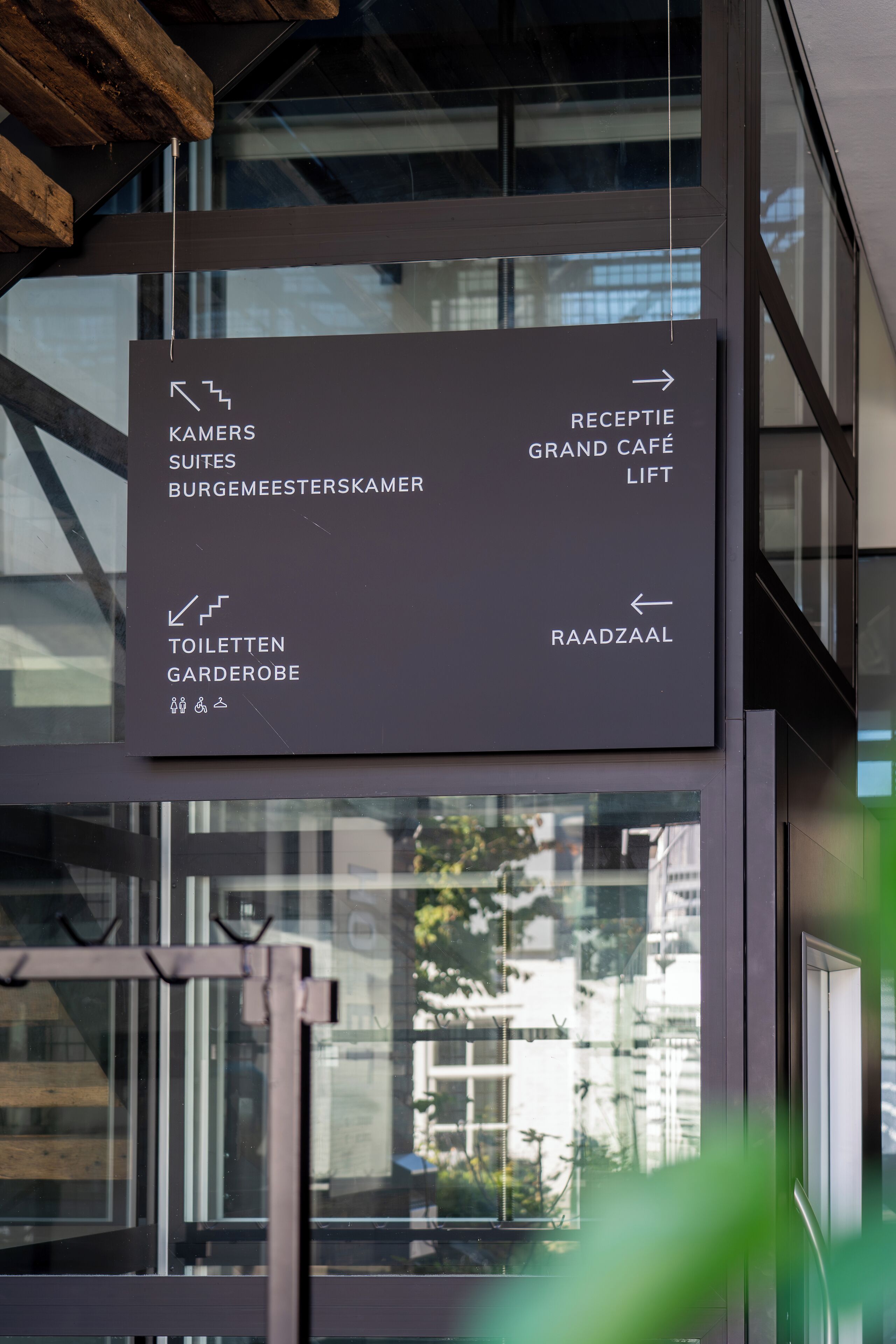 A sign with directions to various hotel facilities including the Grand Café, bathrooms, and a lift.