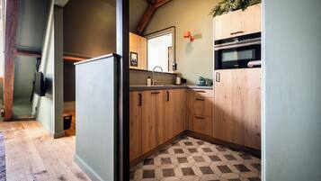 A kitchen with wooden cabinets, a tiled floor, and a built-in oven.