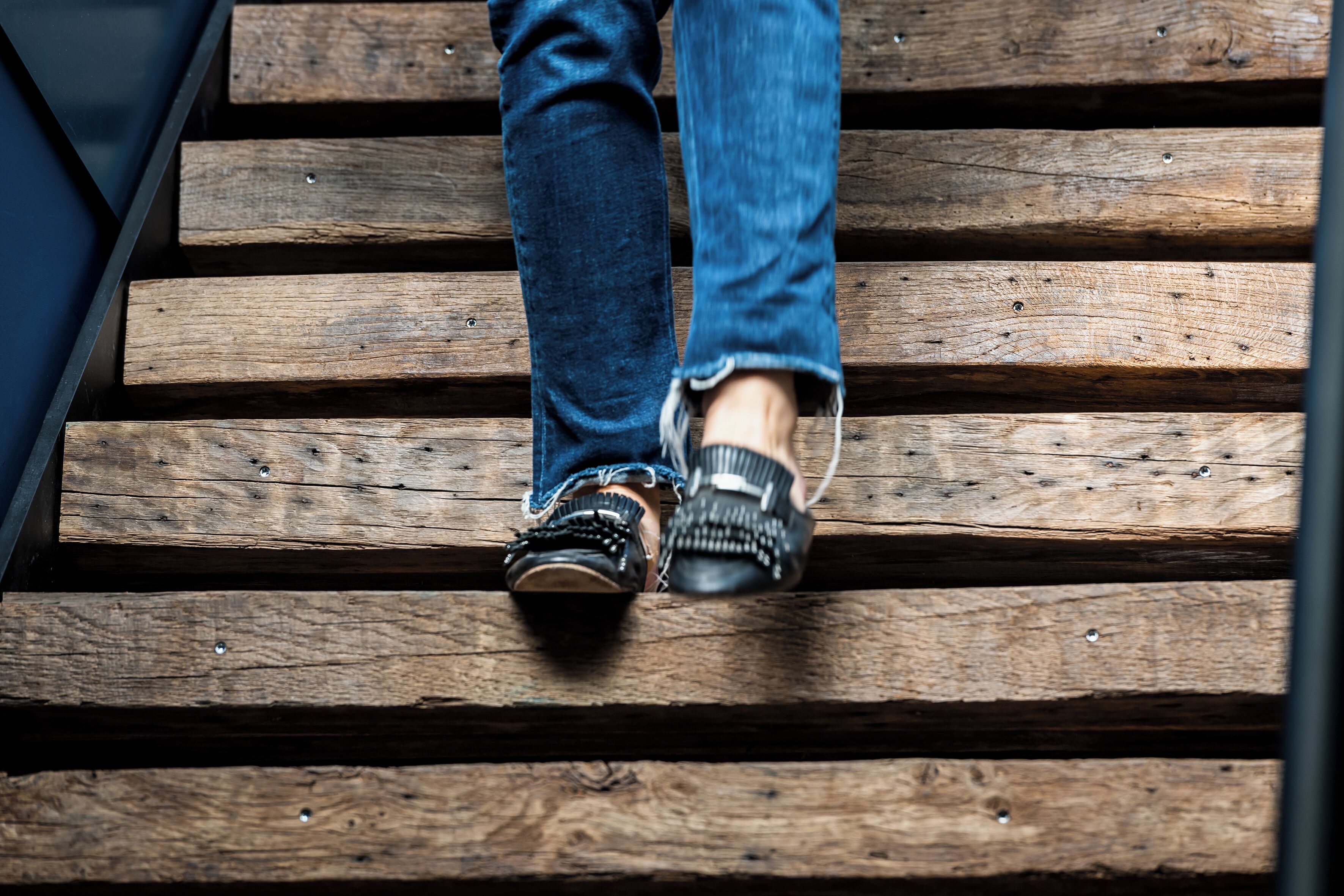 A person descending a wooden staircase.
