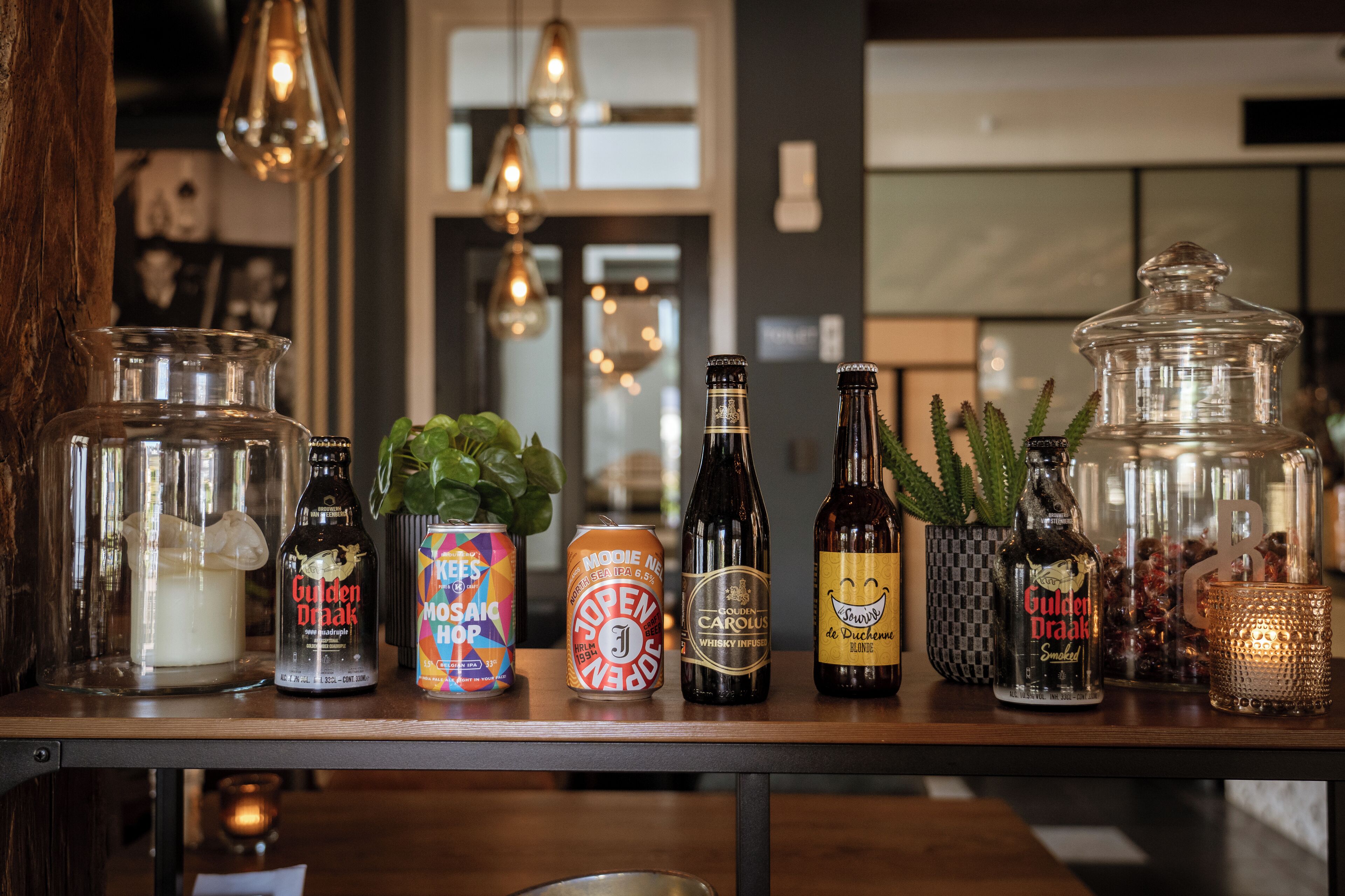 A bar area with various bottles and glasses, including a bottle of Golden Drakkar, a can of Moët & Chandon, and a bottle of Carous.