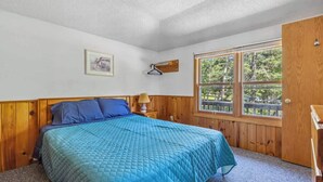 Een kamer met een bed, een raam en een deur.