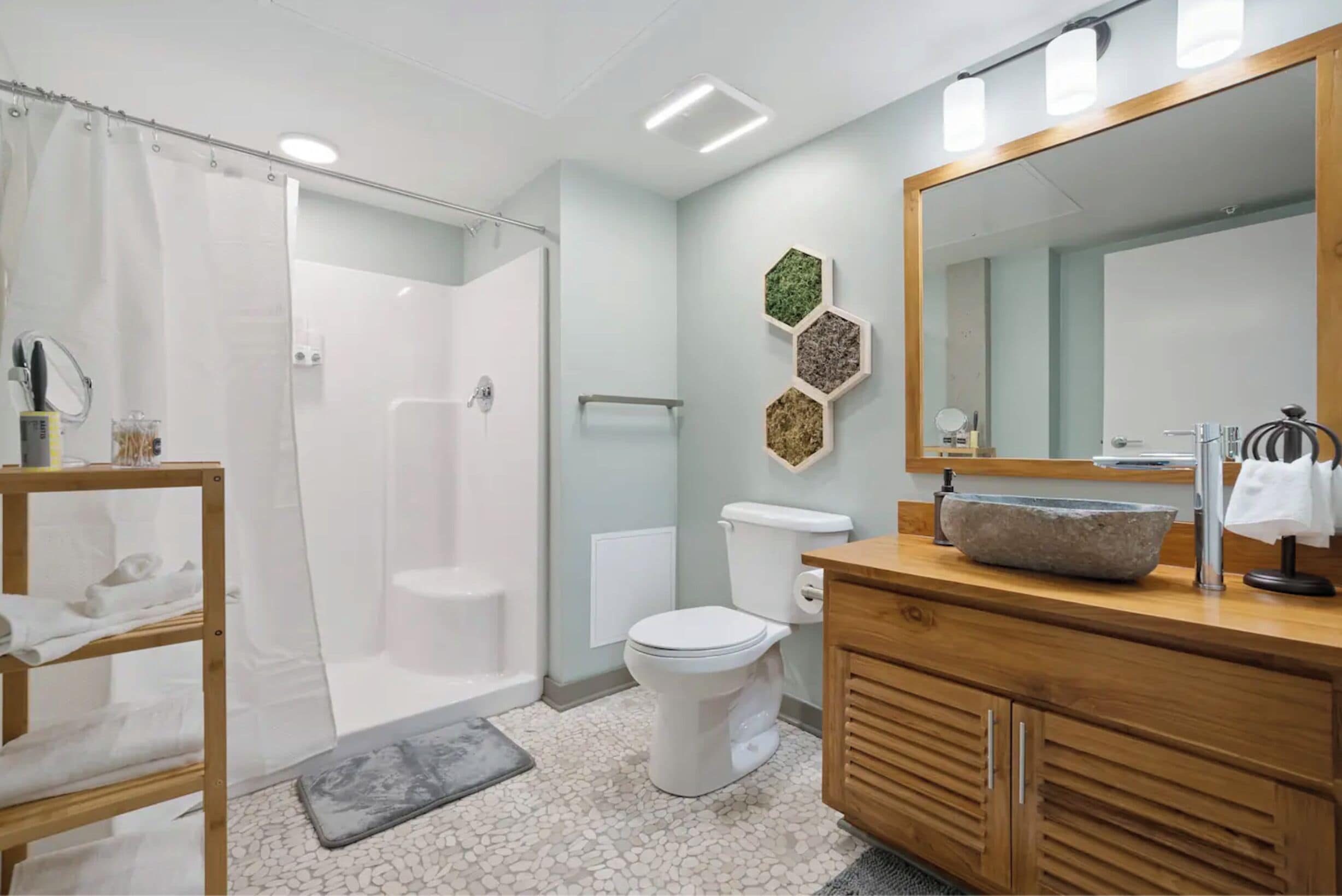 Un baño moderno con ducha, inodoro y tocador.