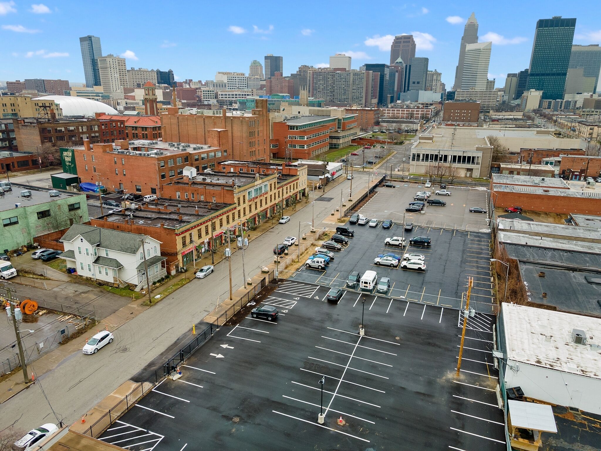 A parking lot with multiple rows of parking spaces and a city skyline in the background.