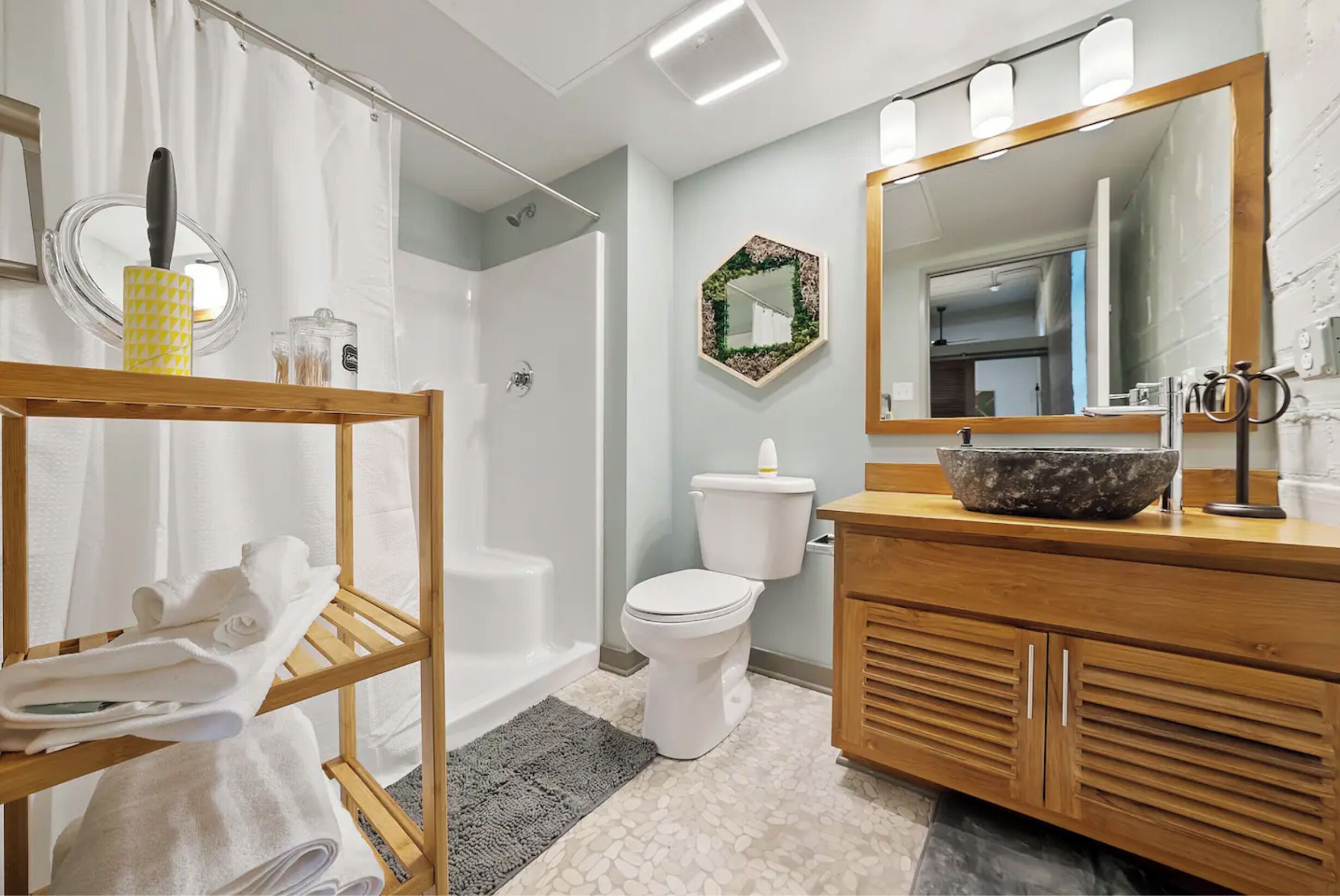 A modern bathroom with a shower, toilet, and vanity.